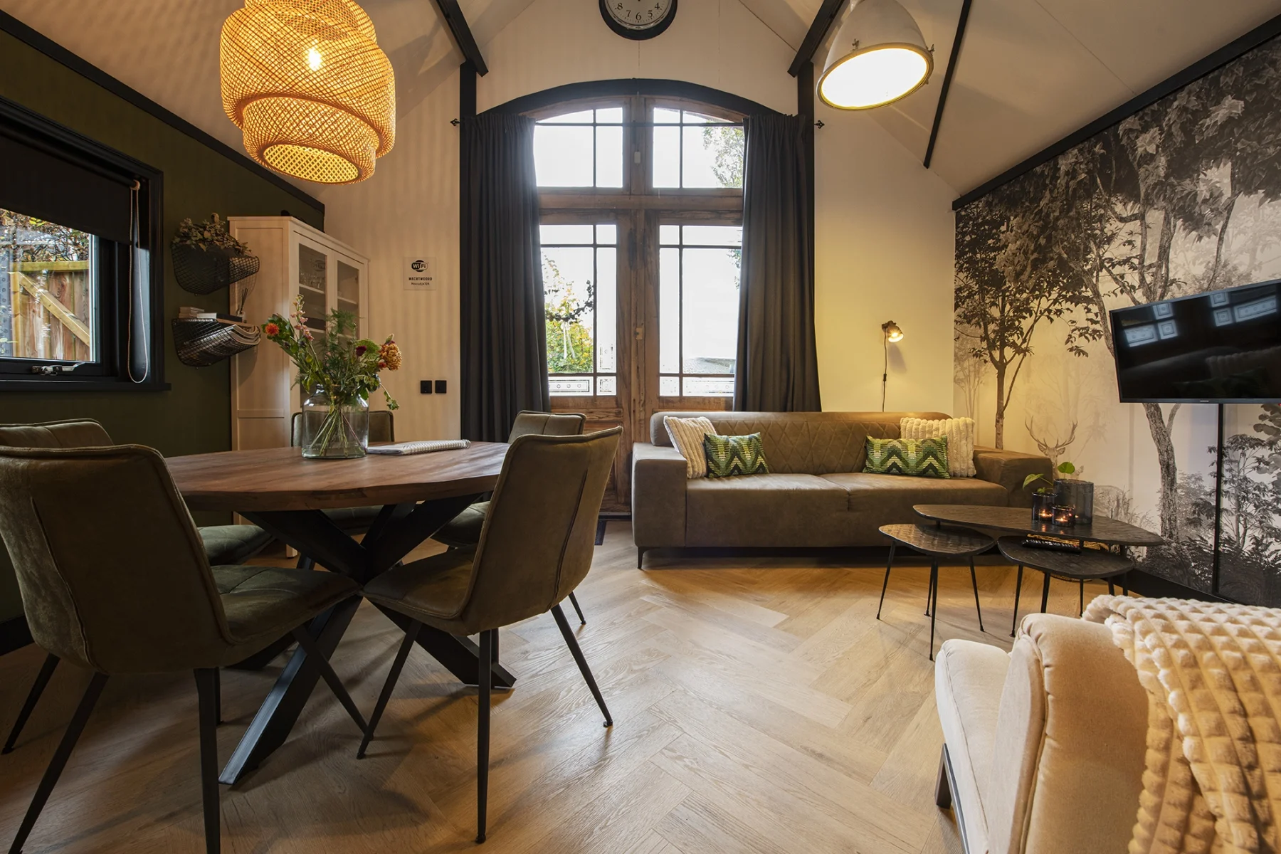 De lichte woonkamer met hoge ramen